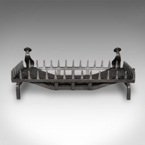 fig 3. An antique dark charcoal iron fire basket featuring a spiked rail and matching end supports with domed finials on arched feet.