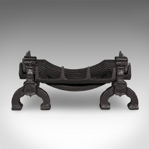 fig 1. A Victorian cast iron fire basket featuring a slatted cradle resting on decorative firedog supports with baluster columns and curved feet.