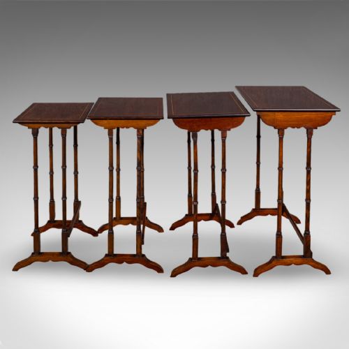 fig 2. A set of four Edwardian mahogany quartetto nesting tables arranged in a stepped row, featuring delicate turned legs, decorative boxwood inlay, and shaped stretchers.