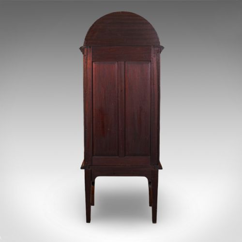 fig 3. A tall Regency oak display cabinet featuring an arched bonnet top with marquetry inlay, a single glazed door enclosing shelves, and carved front legs.