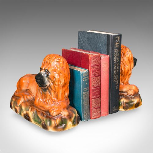 fig 1. A pair of Victorian glazed ceramic recumbent lion bookends in terracotta orange resting on textured green and brown bases.