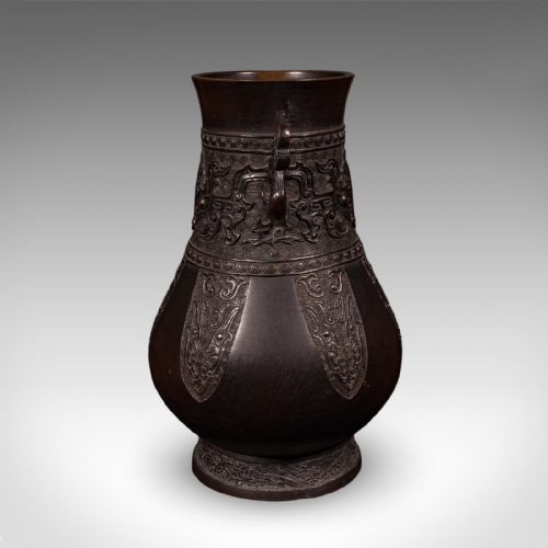 fig 2. A dark patinated bronze Hu vase featuring archaistic relief carvings and twin dragon handles dating to around 1880.