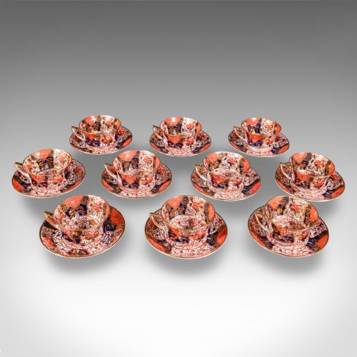 fig 2. A ten-person Victorian bone china tea service decorated with blue, orange, and gold Imari patterns, featuring teacups, saucers, plates, and a waste bowl.