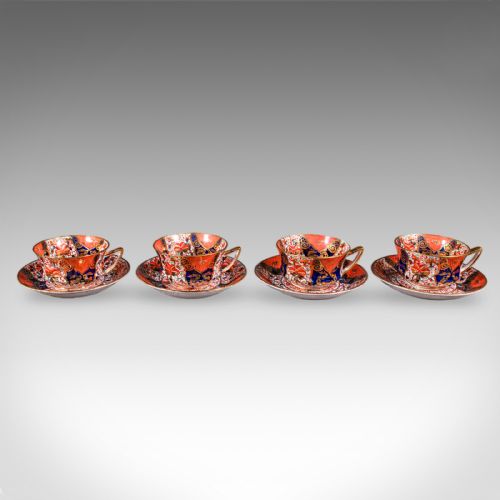 fig 3. A ten-person Victorian bone china tea service decorated with blue, orange, and gold Imari patterns, featuring teacups, saucers, plates, and a waste bowl.