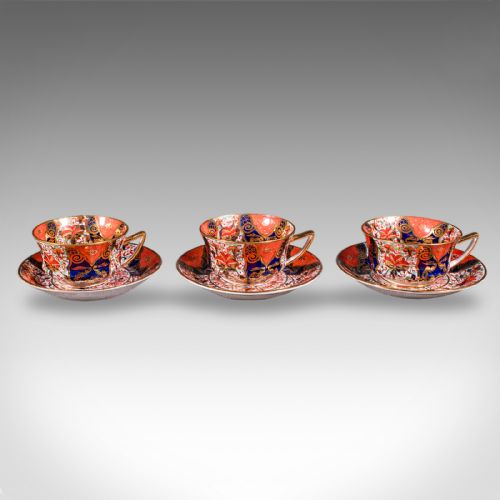 fig 4. A ten-person Victorian bone china tea service decorated with blue, orange, and gold Imari patterns, featuring teacups, saucers, plates, and a waste bowl.