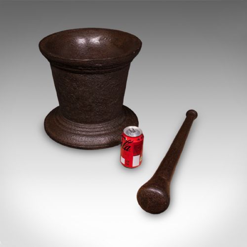 fig 1. A large Georgian cast iron mortar with a flared rim and stepped pedestal base, accompanied by a solid iron pestle.