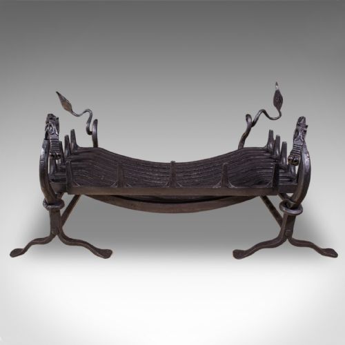 fig 1. A black hand-forged wrought iron fire basket featuring a curved slatted grate supported by four legs with dragon head and tail terminals.