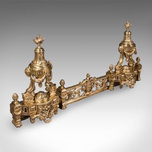 fig 1. An ornate Victorian adjustable brass hearth fender featuring pierced scrollwork and classical urn finials on each end.