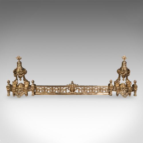 fig 2. An ornate Victorian adjustable brass hearth fender featuring pierced scrollwork and classical urn finials on each end.