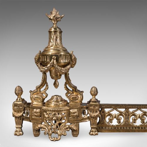 fig 3. An ornate Victorian adjustable brass hearth fender featuring pierced scrollwork and classical urn finials on each end.