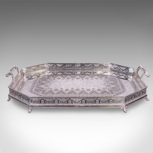 fig 3. A Victorian silver-plated presentation tray featuring geometric surface engraving, a pierced gallery border, twin side handles, and scroll feet.