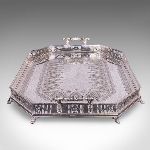 fig 4. A Victorian silver-plated presentation tray featuring geometric surface engraving, a pierced gallery border, twin side handles, and scroll feet.