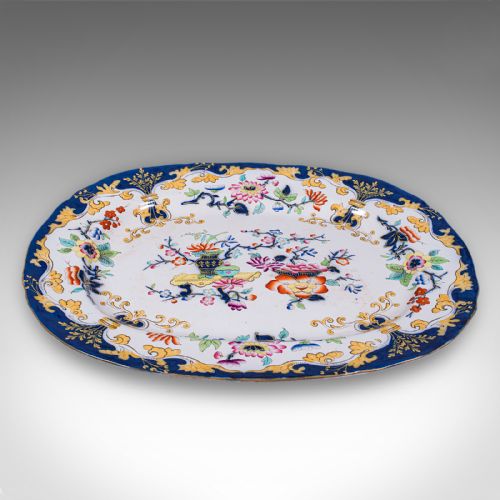fig 1. An oval Victorian ceramic meat platter featuring a cobalt blue and yellow scroll border with central polychrome floral motifs.