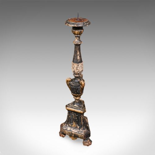 fig 1. A tall Georgian ebonised and giltwood candle pricket featuring a turned baluster stem, urn detail, and a stepped square base resting on claw feet.