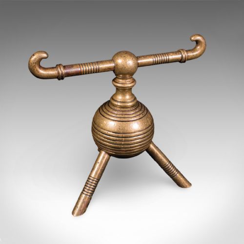 fig 2. A pair of late Victorian brass fireside tool rests featuring ribbed spherical central bodies, tripod legs, and hooked horizontal crossbars.