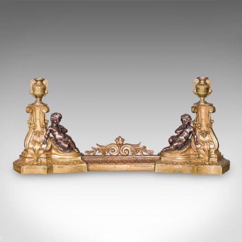 fig 2. An 1880 Victorian adjustable gilt bronze fireplace fender featuring classical urn finials and sitting cherub figures at either end.