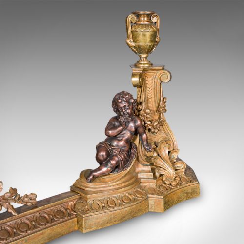 fig 3. An 1880 Victorian adjustable gilt bronze fireplace fender featuring classical urn finials and sitting cherub figures at either end.