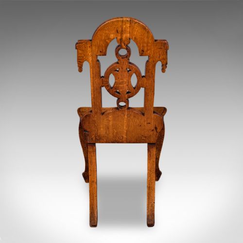 fig 3. A carved Scottish Victorian oak hall chair featuring a decorative pierced backrest, a solid shaped seat, cabriole front legs, and splayed rear legs.