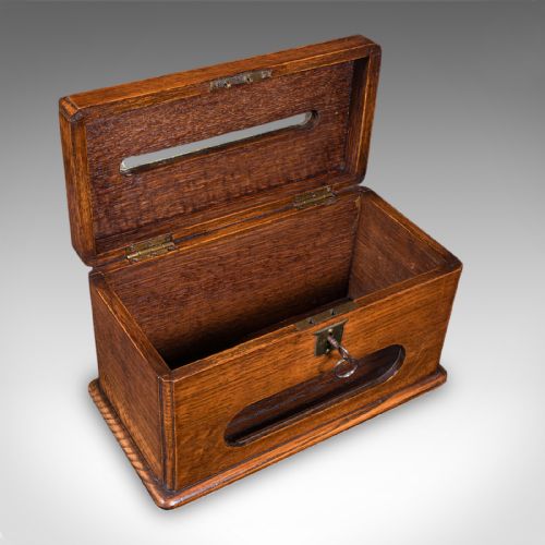 fig 1. A Victorian dark oak wooden letter box featuring a brass letter slot engraved with the word LETTERS on top and a key inserted into the front lock.