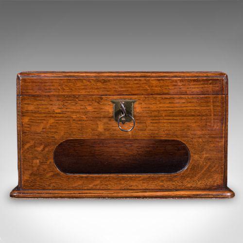 fig 2. A Victorian dark oak wooden letter box featuring a brass letter slot engraved with the word LETTERS on top and a key inserted into the front lock.