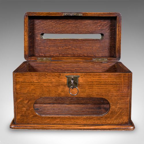 fig 3. A Victorian dark oak wooden letter box featuring a brass letter slot engraved with the word LETTERS on top and a key inserted into the front lock.