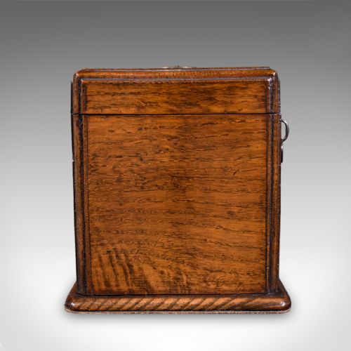 fig 4. A Victorian dark oak wooden letter box featuring a brass letter slot engraved with the word LETTERS on top and a key inserted into the front lock.