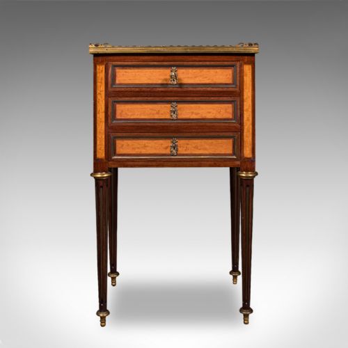 fig 2. A French Louis XVI Revival walnut bedside table with three marquetry drawers, a brass gallery rim, and tapered legs.