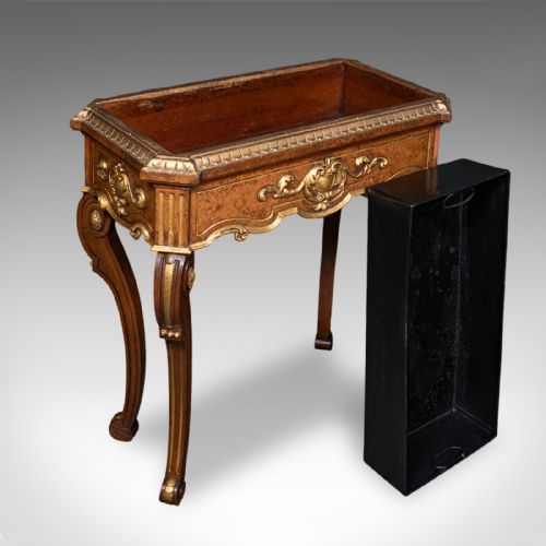 fig 1. An antique French walnut jardiniere table featuring gilded carved mounts, cabriole legs, and a dark recessed internal liner.
