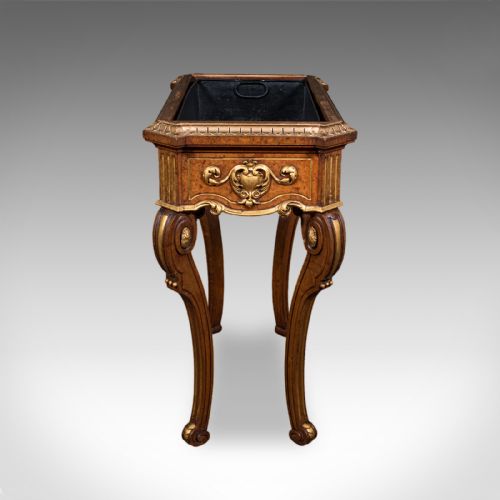 fig 5. An antique French walnut jardiniere table featuring gilded carved mounts, cabriole legs, and a dark recessed internal liner.