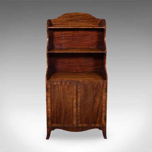 fig 1. An antique Georgian mahogany waterfall bookcase featuring two open receding upper shelves above a two-door base cupboard with a shaped apron.