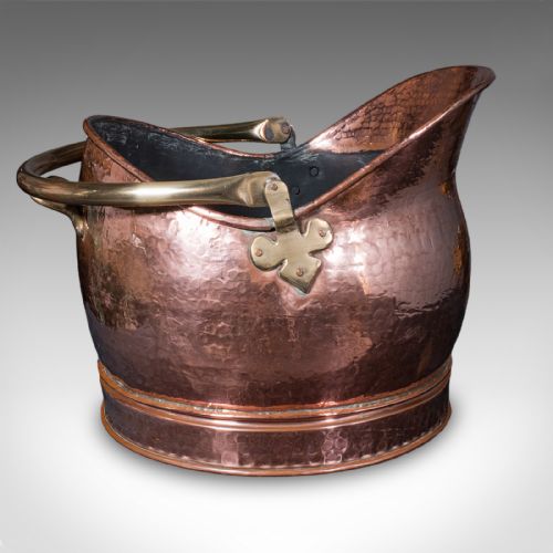 fig 2. An antique Victorian hand-hammered copper coal scuttle featuring a raised rear lip, rolled rim, and an overhead brass swing handle.
