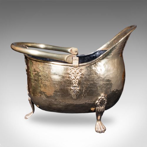 fig 2. An antique English Regency brass coal scuttle featuring a hand-hammered texture, an arched handle, and cast claw feet.