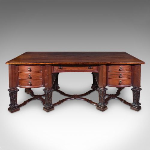 fig 1. A Victorian mahogany partners desk in the Louis XIV Revival style featuring curved pedestals, carved legs, x-frame stretchers, and multiple drawers with turned knobs.