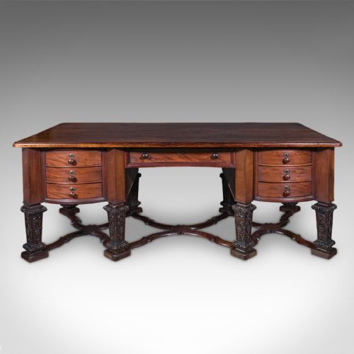 fig 4. A Victorian mahogany partners desk in the Louis XIV Revival style featuring curved pedestals, carved legs, x-frame stretchers, and multiple drawers with turned knobs.