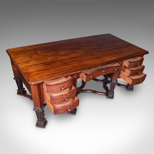 fig 6. A Victorian mahogany partners desk in the Louis XIV Revival style featuring curved pedestals, carved legs, x-frame stretchers, and multiple drawers with turned knobs.