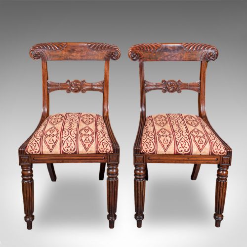 fig 1. A pair of English William IV mahogany side chairs featuring carved back rails, reeded front legs, and pattern-upholstered seats.