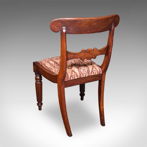 fig 3. A pair of English William IV mahogany side chairs featuring carved back rails, reeded front legs, and pattern-upholstered seats.