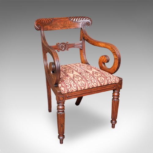 fig 2. A pair of antique William IV mahogany elbow chairs featuring carved crest rails, sweeping scroll arms, fluted turned front legs, and patterned upholstery.