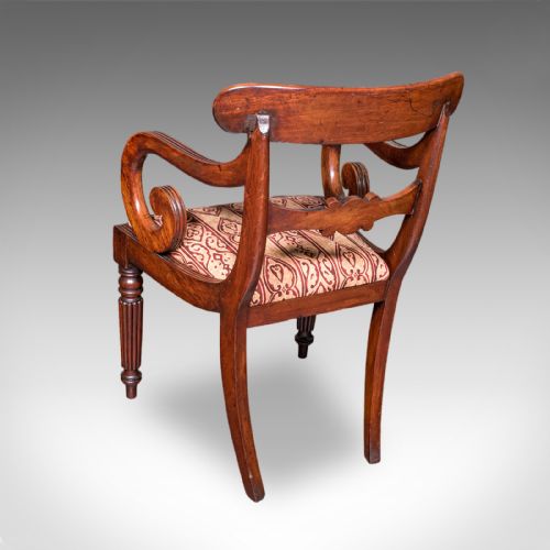 fig 3. A pair of antique William IV mahogany elbow chairs featuring carved crest rails, sweeping scroll arms, fluted turned front legs, and patterned upholstery.
