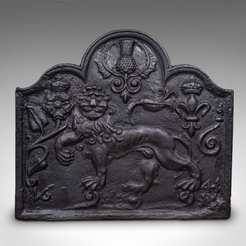 fig 1. An arched cast iron fire back decorated with a central lion relief, a thistle motif at the apex, and fleur-de-lis accents.