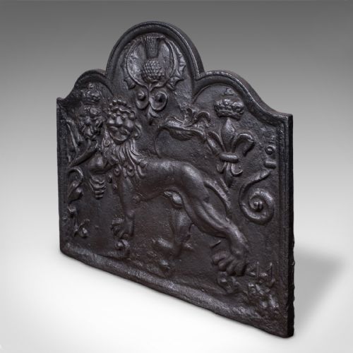 fig 2. An arched cast iron fire back decorated with a central lion relief, a thistle motif at the apex, and fleur-de-lis accents.