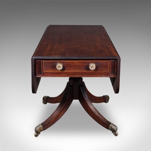 fig 3. A Regency dark mahogany drop-leaf Pembroke dining table with a central reeded pedestal, four splayed legs with brass castors, and a frieze drawer.