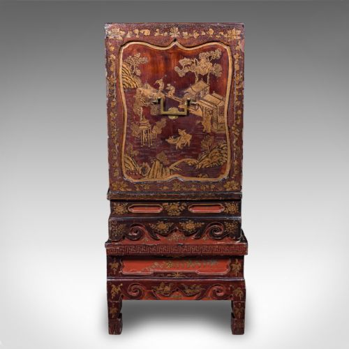 fig 3. An antique reddish-brown lacquered Chinoiserie campaign cabinet featuring gold gilt landscape scenes, brass corner mounts, and two open lower drawers on a matching stand.