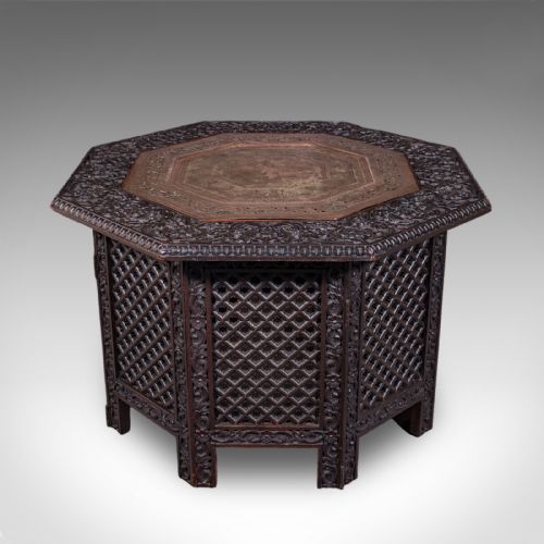 fig 1. An octagonal dark wood Anglo-Indian tea table featuring deeply carved lattice work side panels and an engraved copper inset top.