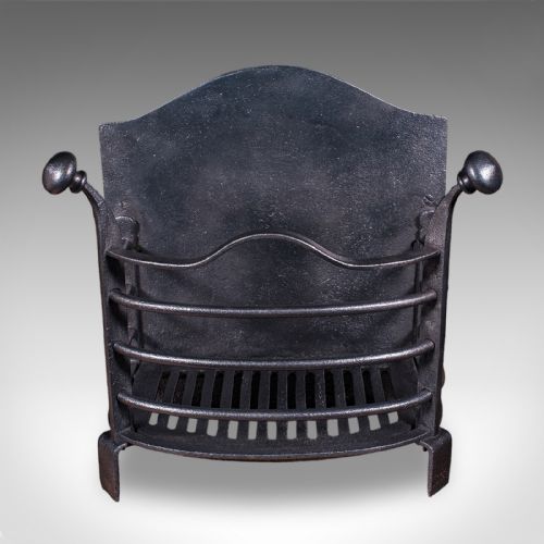 fig 1. A small Victorian black cast iron freestanding fire grate featuring a curved front basket, turned finial posts, and an arched backplate.