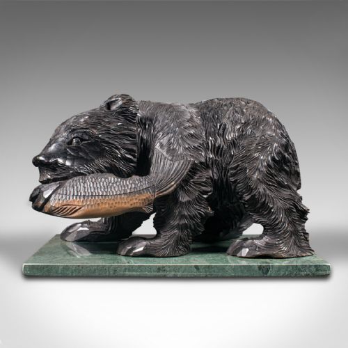 fig 1. A Japanese carved cedar bear holding a fish in its mouth mounted on a green polished stone base.