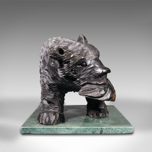 fig 2. A Japanese carved cedar bear holding a fish in its mouth mounted on a green polished stone base.
