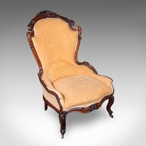 fig 1. An early Victorian carved mahogany salon armchair upholstered in gold velvet fabric accompanied by a matching small footstool.