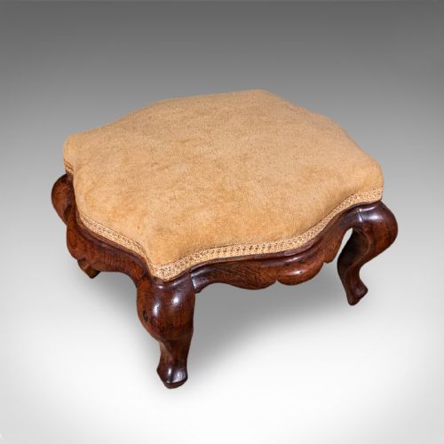 fig 2. An early Victorian carved mahogany salon armchair upholstered in gold velvet fabric accompanied by a matching small footstool.