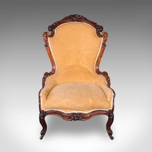 fig 3. An early Victorian carved mahogany salon armchair upholstered in gold velvet fabric accompanied by a matching small footstool.